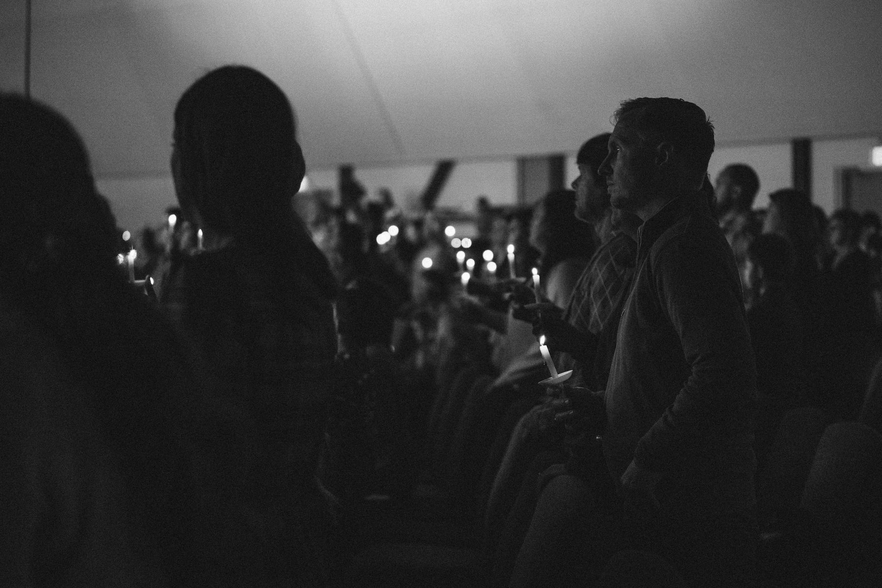 Hands holding lit candles during the Christmas Eve service