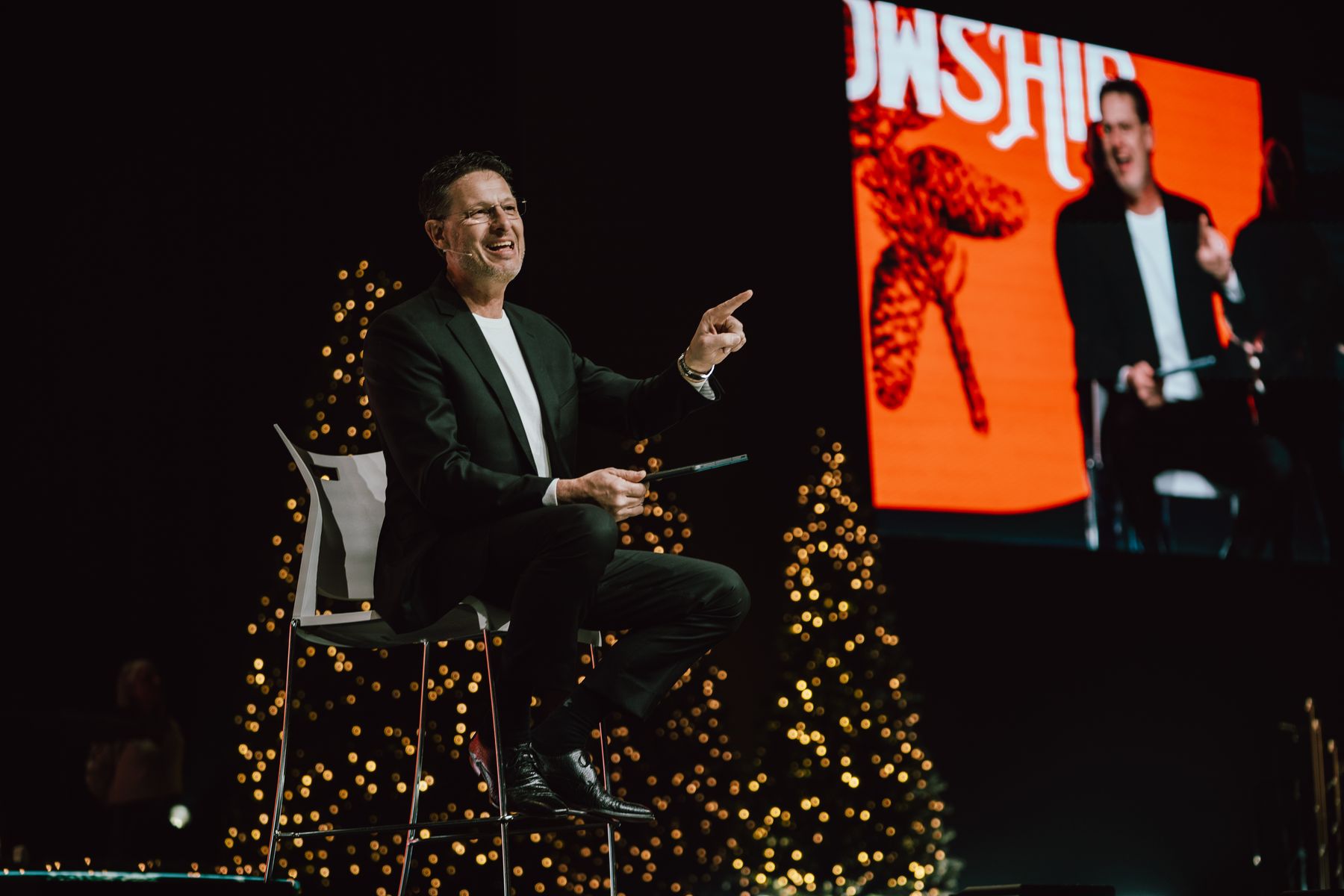 Pastor Mark Allen on stage, smiling, during the Christmas Eve service