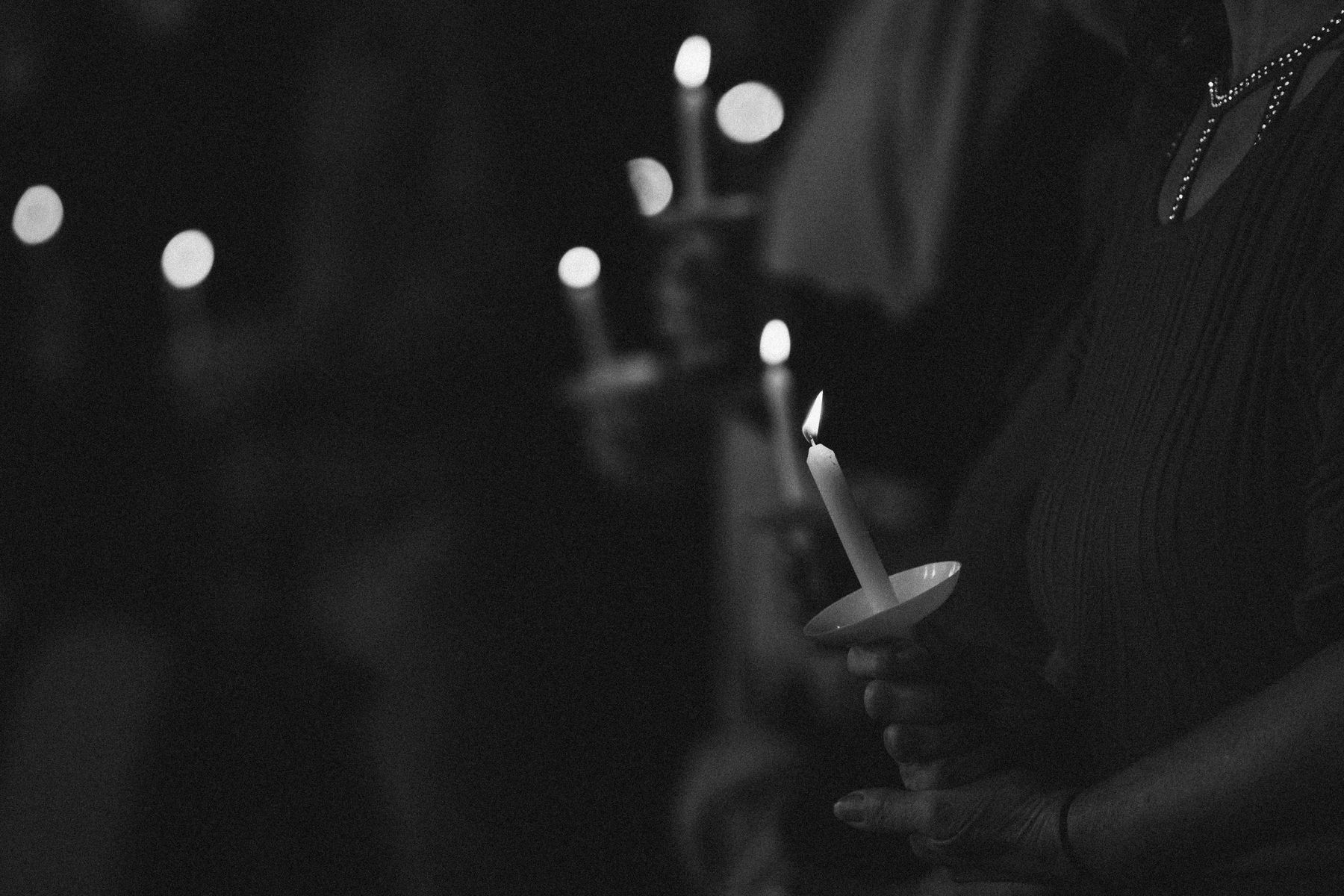 A single candle held during the service